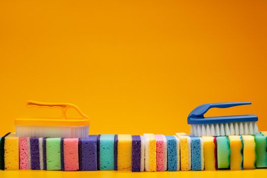 Stacked household cleaning sponges on yellow background