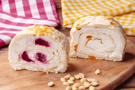 Biscuit roulade with cherry on wooden board
