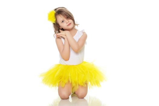 Little girl in a yellow skirt and white t-shirt.