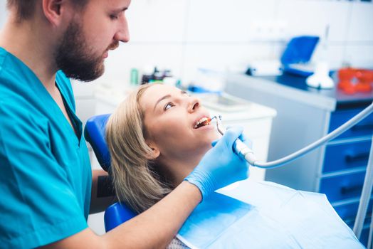 Dentist treating blond smiling girl