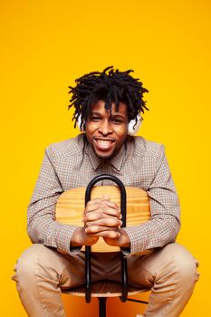 young handsome african american guy student posing cheerful and gesturing on yellow background, lifestyle people concept close up