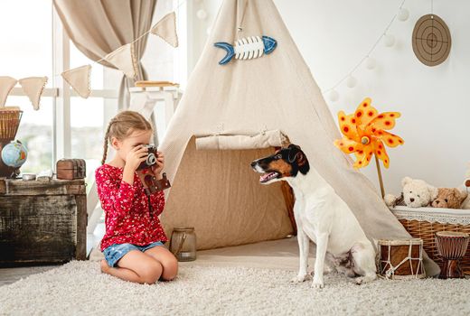 Little girl with camera next to dog