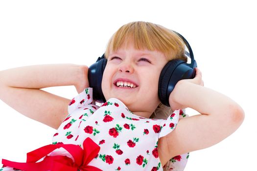 beautiful little girl in white dress listening to music with headphones