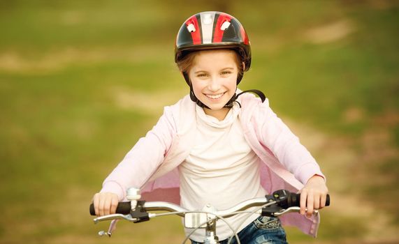 smiling little girl riding a bike