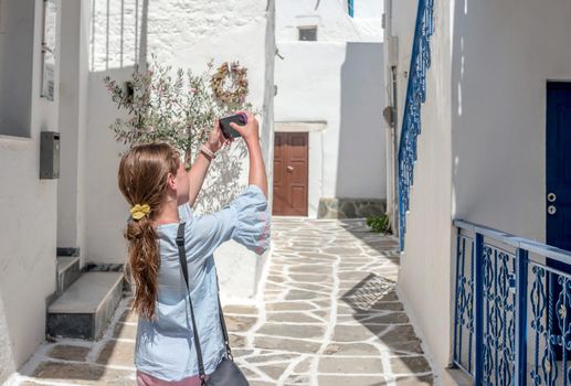Gorl taking photo of rustic Greek architecture