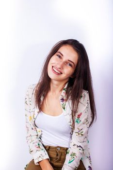 young pretty teenage hipster girl posing emotional happy smiling on white background, lifestyle people concept close up