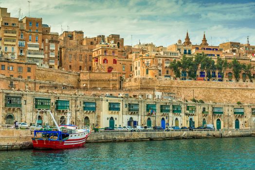 Valletta embankment with traditional colorful doors and anchored ship