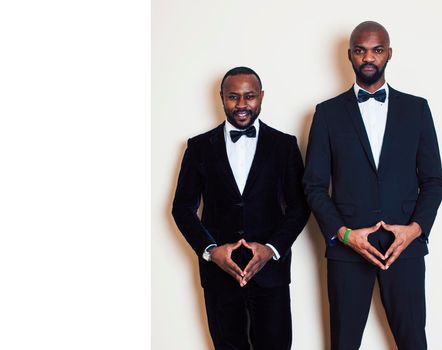 two afro-american businessmen in black suits emotional posing, gesturing, smiling. wearing bow-ties