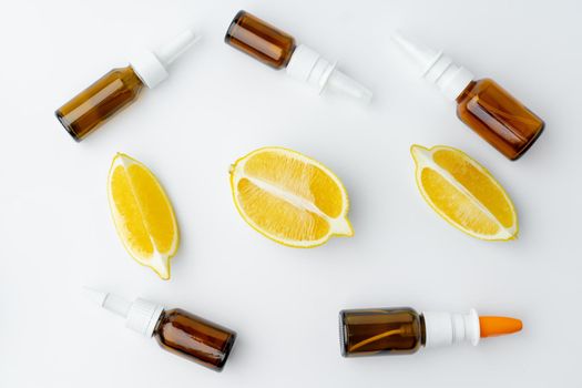 Essential oil bottles and citrus fruit on white background