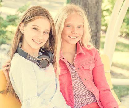 Beautiful smiling girls sitting on the bench