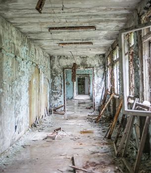 gloomy corridor with broken window frames and debris