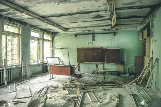 ruined class room with desks and blackboards in Pripyat school