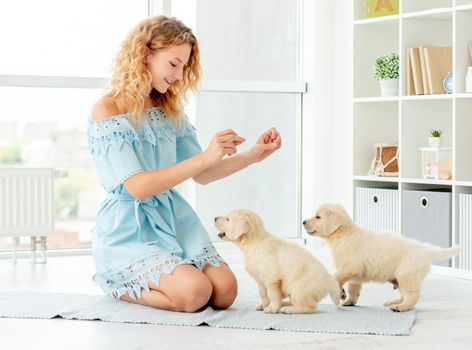 Happy girl teaching puppies