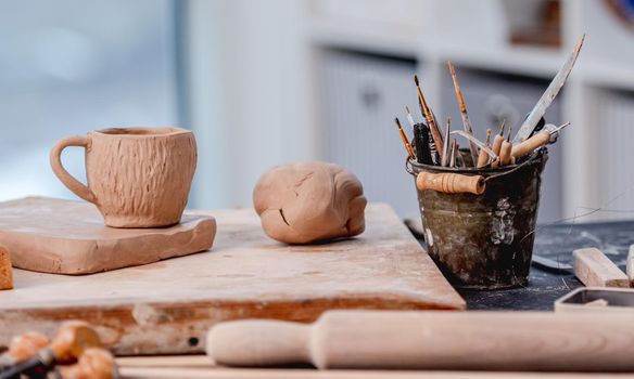 Pottery tools, cup and clay at workshop