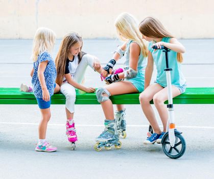 Little girls putting on rollerskates