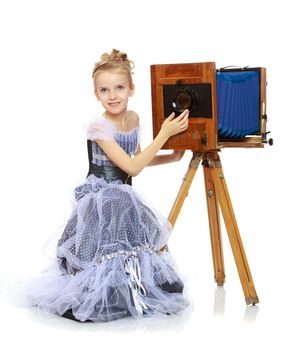 Little girl posing near the old camera.