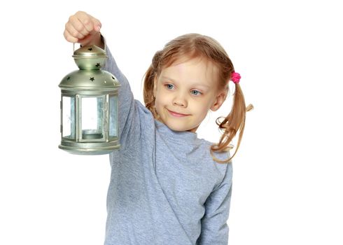 A little girl is holding a lamp.
