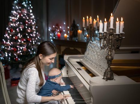Mom with a child near a white piano