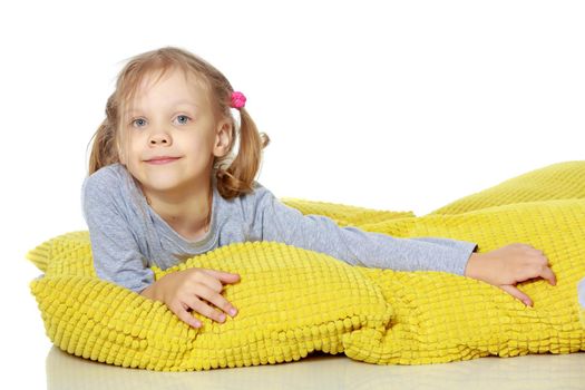 A little girl lies on a pillow.