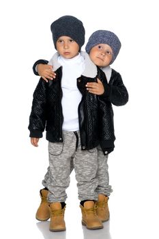 Two little boys in black jackets and hats.