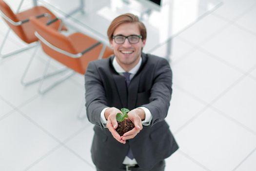 young businessman showing green sprout