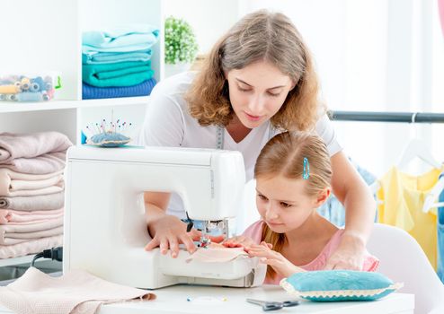 Mother and daughter sewing