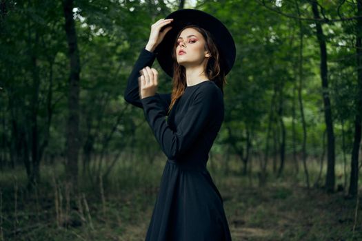 woman dressed as a witch in the forest Halloween fantasy ritual