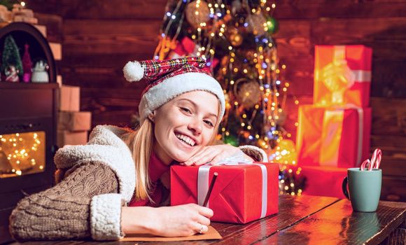 Cute blonde woman with Christmas gift. Girl celebrating noel party.