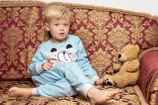 Little boy in pajamas with a teddy bear.