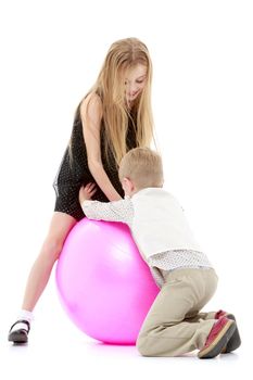 Toddler boy and girl playing with ball.