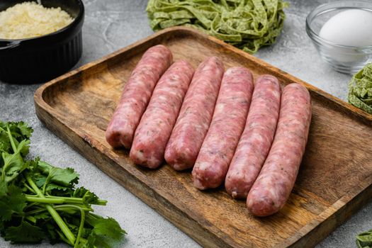 Raw Tagliatelle sausages ingredients, on gray stone table background
