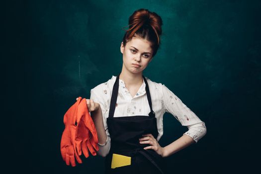 woman with rubber gloves in apron cleaning housework