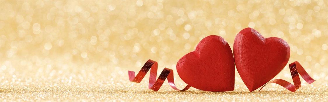 Two red hearts on golden background