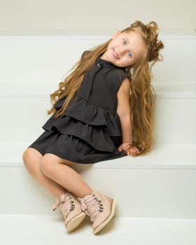 Elegant, beautiful girl in a dress. In full growth. The concept of youth fashion, happy childhood.
