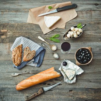 French cuisine. Different types of cheese, wine and other ingredients on a wooden table