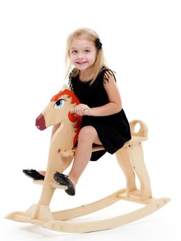 Girl swinging on a wooden horse.