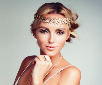 young blond woman dressed like ancient greek godess, gold jewelry close up isolated, summer trends