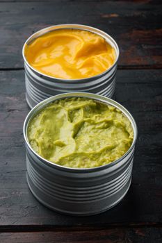 Canned cheese and guacamole sauce, on old wooden table