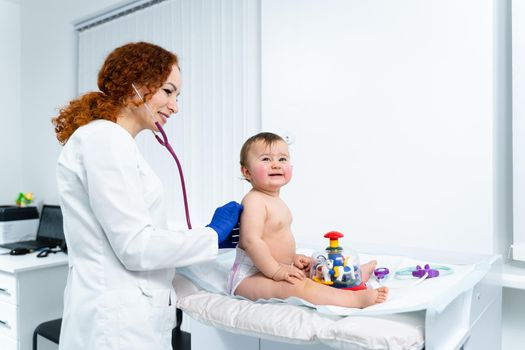 Pediatrician providing healthcare for her baby patient in the office of a specialized clinic for children. Neonatologist. Medical appointment little child one year old in the clinic. Health care of infant, children, kid