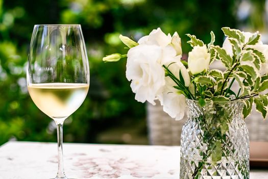 White wine in luxury restaurant on summer garden terrace, wine tasting experience at winery in the vineyard, gourmet tour and holiday travel
