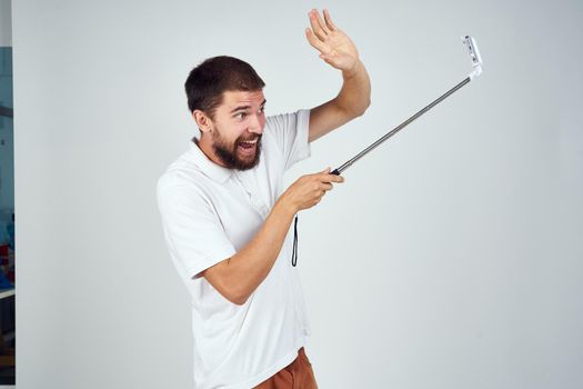 bearded man in white t-shirt selfie stick photo technology