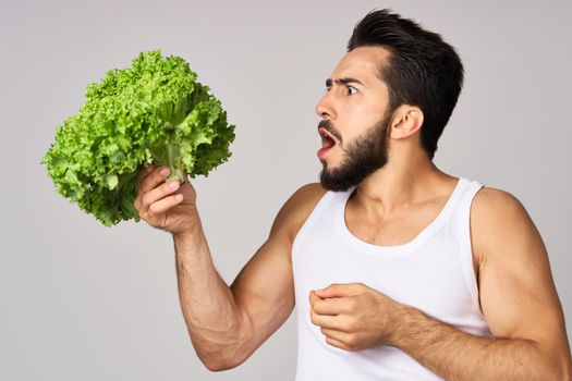 Cheerful man lettuce leaves healthy food posing