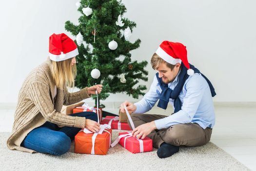 Holidays, family and festive concept - Couple with Christmas gifts at home