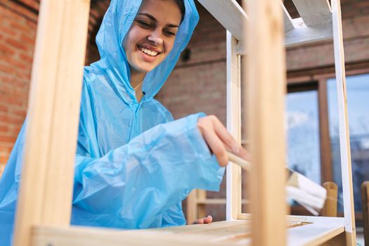 cheerful woman house painter repairing wooden structure