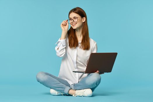 woman with laptop learning internet online education blue background. High quality photo