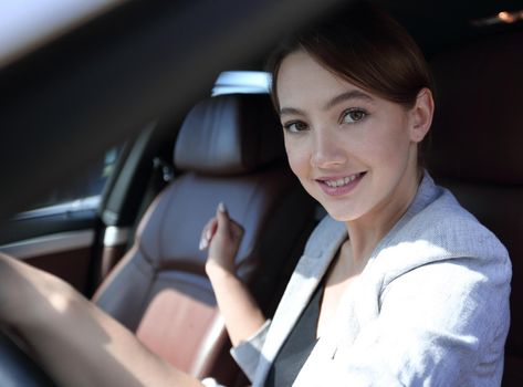 successful business woman sitting behind the wheel of a ca