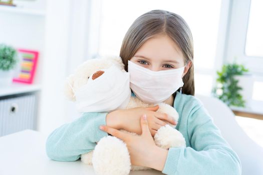 Girl with plush teddy wearing masks