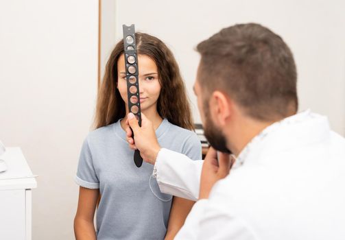 Oculist examines teenage girl in clinic