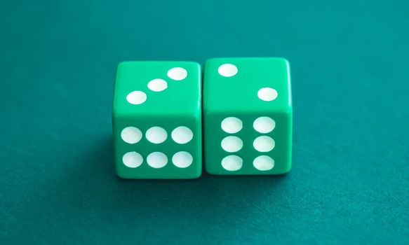 Green dice on felt background