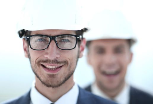 Profile portrait of two smiling builders looking at camera. Close-up